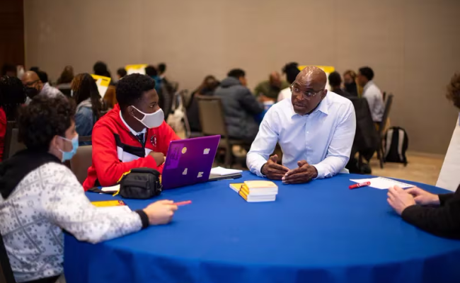 Kelly Harris (right) speaks with students at a convention for high school students in New Jersey in May 2022.