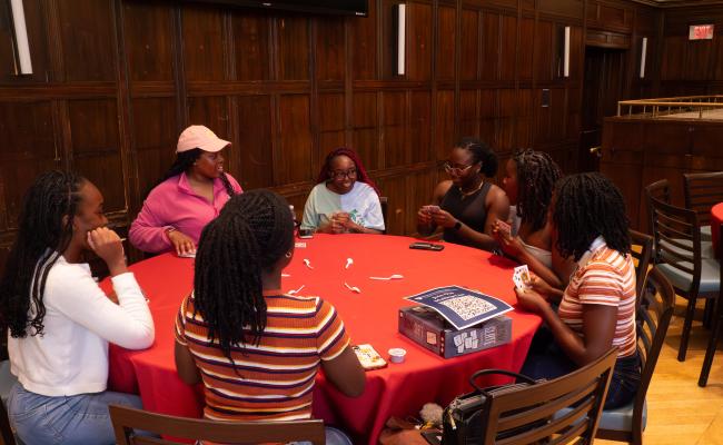 A group of Summer Institute students playing cards around a table.