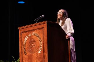 Professor Roberts stands at a podium mid-speech.