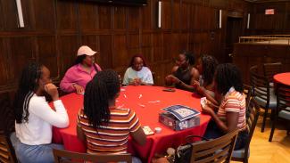 A group of Summer Institute students playing cards around a table.